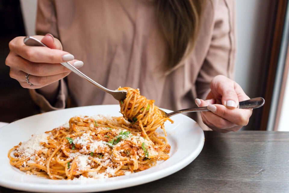 woman swirling pasta onto fork