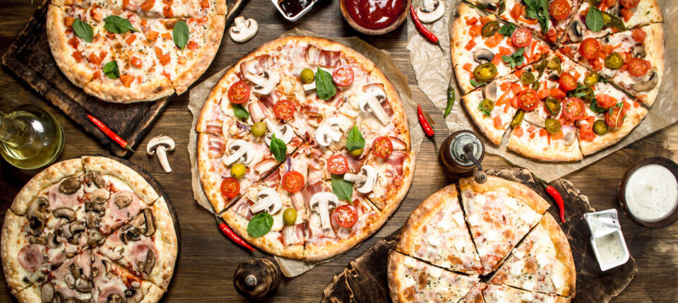 various pizzas on wood table